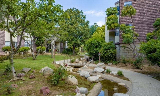Meandering Stream and Fish Pond at The Oaks of Pasadena — A Serene Senior Living Community Established in 1981 Peaceful stream flowing through The Oaks of Pasadena senior living community, leading to a scenic fish pond surrounded by trees and walking paths — Opened in 1981