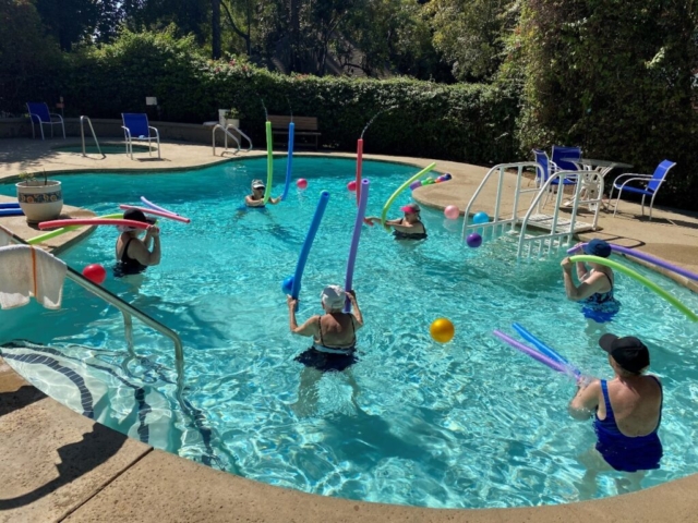 Summer Aquasize Class for Seniors at The Oaks of Pasadena Heated Pool Residents enjoying a weekly summer pool exercise class in the heated outdoor pool at The Oaks of Pasadena senior living community.
